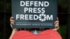 FILE - An employee of the country's largest TV network ABS-CBN, holds a slogan during a rally outside the House of Representatives in Manila, Philippines, July 9, 2020.