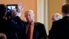 President Donald Trump, followed by Senate Majority Leader Mitch McConnell., waves as he arrives for a lunch with Republican senators at the Capitol in Washington, Oct. 24, 2017.