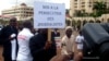 FILE - A Cameroonian journalist holds a sign reading "No to the persecution of journalists" during a free speech rally in Yaounde, Cameroon.