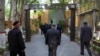 Uyghurs and other members of the faithful walk under an arch with security cameras as they leave after prayers at the Id Kah Mosque in Kashgar in western China's Xinjiang Uyghur Autonomous Region, as seen during a government organized trip for…