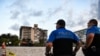 La police monte la garde près d'un immeuble partiellement effondré, Miami Beach, le 24 juin 2021.