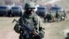 An armed man, believed to be a Russian soldier, stands on guard outside a military base in Perevalnoye, near the Crimean city of Simferopol, March 21, 2014.