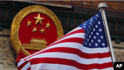 中國國徽與美國國旗。
