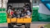 Migrant workers and their families ride in the back of a truck as they wait to be admitted to a field hospital for COVID-19 patents, Monday, Jan. 4, 2021, in Samut Sakhon, South of Bangkok, Thailand. (AP Photo/Gemunu Amarasinghe) 