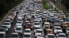 FILE - Traffic moves at dusk in New Delhi, India, Sept. 23, 2014. New Delhi is beginning an experiment to reduce the number of private cars on roads in hopes of curbing air pollution levels.