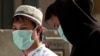 FILE - Muslim pilgrims wear surgical masks to help prevent infection from the MERS respiratory virus in Mecca, Saudi Arabia, May 13, 2014.