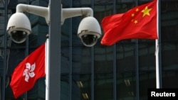 資料照：在香港政府總部大樓外監控攝像頭後的中國國旗和香港特區旗幟。
