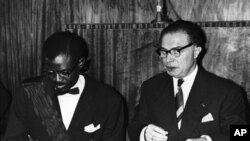 Patrice Lumumba, waziri mkuu wa Congo akitia saini tangazo la uhuru mjini Leopodville, Congo. Kulia kwake ni waziri mkuu wa zamani wa Ubelgiji Gaston Eyskens, aliyretia saini kwa niaba ya Ubelgiji. Ubelgiji iliitawala Congo kwa miaka 70.