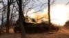 Ukrainian service members fire an artillery piece in the Donetsk region
