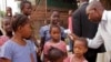 FILE - A health care worker, right, takes the temperatures of school children for signs of the Ebola virus before they enter their school in the city of Conakry, Guinea, Jan. 19, 2015.