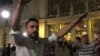 A Syrian man organizes a sit-in outside Budapest's East railway station Friday night as thousands of stranded migrants await passage to Austria, and ultimately Germany, Sept. 4, 2014 (VOA / L. Ramirez).