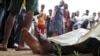 FILE - Residents look at the slain bodies of people killed at the Cibitoke district in Burundi's capital Bujumbura, Dec. 9, 2015. 