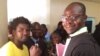 N2A Teguil, à gauche, en jaune, aux côtés de ses avocats, devant le bureau du procureur de la République, à N’Djamena, Tchad, 30 octobre 2018. (VOA/André Kodmadjingar)