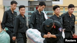 Một cảnh sát cúi lạy dân Đồng Tâm sau khi được thả ngày 22 tháng Tư. (Hình: REUTERS/Kham)
