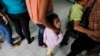 FILE - Women and their children wait in line to register at the Honduran Center for Returned Migrants after being deported from Mexico, in San Pedro Sula, northern Honduras June 20, 2014.
