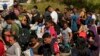 Migranti čekaju da budu procesuirani na graničnom prelazuu Teksasu, 19. oktobar 2023. (AP Photo/Eric Gay)
