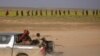 FILE - Children from the Yazidi community, who were recently freed after being captured by Islamic State fighters, ride on a back of a truck near Baghouz, Deir el-Zour province, Syria, March 6, 2019.