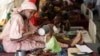 FILE - A mother feeds her malnourished child at a feeding center in Maiduguri, Nigeria, Aug. 29, 2016.