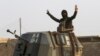 A member of Iraq's elite counterterrorism forces in a military convoy flashes a victory sign as forces advance toward Islamic State positions in the village of Tob Zawa, about 9 kilometers (5½ miles) from Mosul, Iraq, Oct. 25, 2016.