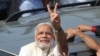 India's main opposition Bharatiya Janata Party’s prime ministerial candidate Narendra Modi displays the victory symbol to supporters after casting his vote in Ahmadabad, India, April 30, 2014. 