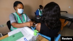 Nesi akimpiga mtu chanjo ya AstraZeneca ya COVID-19 kwa mwanamke mmoja katika hospitali ya taifa ya nchi hiyo mjini Abuja, Nigeria March 31, 2021.