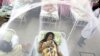 Enclosed in a mosquito net, Nadia Gonzalez recovers from a bout of dengue fever at a hospital in Luque, Paraguay, Feb. 5, 2016. Dengue, like the Zika virus, is transmitted by the same vector, the Aedes aegypti mosquito. 