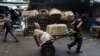 FILE - Vendor Carmen Diaz, 84, is pulled by a market porter as she makes her way home at the end of her work day in the Oriental Market in Managua, Nicaragua, April 30, 2015.