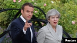 លោក Emmanuel Macron ប្រធានាធិបតី​បារាំង​អម​ដំណើរ​លោកស្រី Theresa May នាយក​រដ្ឋមន្ត្រី​អង់គ្លេស ទៅ​កាន់​សន្និសីទ​កាសែត​នៅ​វិមាន Elysee ក្នុង​ក្រុង​ប៉ារីស ប្រទេស​បារាំង កាលពី​ថ្ងៃទី១៣ ខែមិថុនា ឆ្នាំ២០១៧។