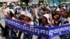 Cambodian activists shout slogans during a march toward the National Assembly, in Phnom Penh, Cambodia, Thursday, May 29, 2014. Some 300 activists on Thursday delivered petitions to the National Assembly and Anti-Corruption Unit headquarters to demand the government to stop giving land concession to private companies. The banner reads " Absolutely against the corruption in the society." (AP Photo/Heng Sinith)