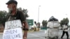 Un homme fait la manche (g) tandis qu'un autre collecte des matériaux recyclables, à une intersection de rue à Johannesburg, en Afrique du Sud, le 16 mars 2016.
