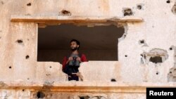 FILE - A fighter from the Free Syrian Army is seen in the Yadouda area of Dara'a, southern Syria, May 29, 2018.