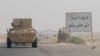 FILE - A road sign welcomes people to the town of Deir el-Zour in Syria, Sept. 20, 2017.