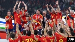 Raja Spanyol Felipe mengangkat piala dan merayakan kemenangan timnas Spanyol meraih juara turnamen sepak bola Piala Eropa dalam laga final antara Spanyol dan Inggris di Olympiastadion di Berlin, Minggu, 14 Juli 2024. (Foto: Adrian Dennis/AFP)