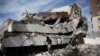 Men walk on the rubble of the Chamber of Trade and Industry headquarters after it was hit by a Saudi-led airstrike in Sana'a, Yemen, Tuesday, Jan. 5, 2016. 