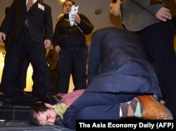 A man, bottom center, who attacked U.S. ambassador to South Korea Mark Lippert, is detained by police at the Sejong Cultural Institute in Seoul, March 5, 2015.