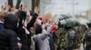 Demonstrators stand with their hands up in front of riot police line during an opposition rally to protest the official presidential election results in Minsk, Belarus, Nov. 1, 2020.