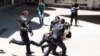 Turkish riot police try to protect a person from a group of people of unknown affiliation who were attacking a rally of pro-Kurdish Peoples' Democracy Party (HDP) in Erzurum, Turkey, June 4, 2015. 