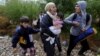 FILE - Migrants cry and walk towards Gevgelija in Macedonia after crossing Greece's border, Macedonia. 