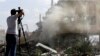 A journalist films the wreckage of a building described as part of the Scientific Studies and Research Centre (SSRC) compound in the Barzeh district, north of Damascus, during a press tour organized by the Syrian Information Ministry, on April 14, 2018.