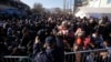 FILE - Serbian police officer attempt to organize migrants queuing to get registered at a refugee center in the southern Serbian town of Presevo, Nov. 16, 2015. 