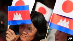 FILE: Cambodians hold Japan's flags and their national flags as they listen to Prime Minister Hun Sen's speech during an inauguration ceremony of a road funded by Japan for its official use at Kdey Takoy village, outside of Phnom Penh, Cambodia, Tuesday, March 13, 2018. 