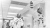 FILE - Apollo 11 astronaut Neil Armstrong waves to well-wishers on the way out to the transfer van, Cape Canaveral, Florida, July 16, 1969. Mike Collins and Buzz Aldrin follow Armstrong down the hallway.