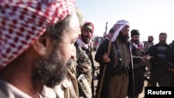 FILE - Yazidi fighters gather on the summit of Mount Sinjar as they head to battle Islamic State militants, in Iraq, Dec. 21, 2014. IS swept into Sinjar town and surrounding villages in early August; many residents were from the Yazidi religious community.