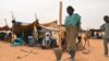 FILE - A woman prepares a meal at a Malian refugee camp in Chinegodar, western Niger, close to the Malian border, February 4, 2012.