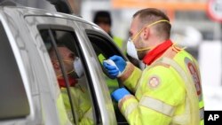 Фото: медпрацівник міряє температуру у подорожуючого на кордоні Австрії та Італії, березень 2020 року