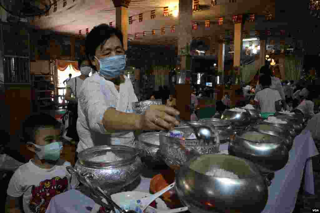 ស្ត្រីម្នាក់កំពុងរាប់បាត្រ នៅវត្តថាន់ រាជធានីភ្នំពេញ អំឡុងពេលប្រារព្ធពិធីបុណ្យចូលឆ្នាំខ្មែរថ្ងៃទី២ នៅថ្ងៃទី១៤ ខែមេសា ឆ្នាំ២០២០។ (កាន់ វិច្ឆិកា/VOA)