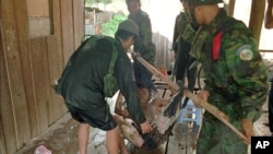 An unidentified injured soldier (uncertain who he belongs to) is helped in a make-shift stretcher by his comrades after a tank he was riding was hit by a rocket Sunday, July 6, 1997, a fighting between Hun Sen and Prince Ranarridh's armie near Phnom Penh's university on the outskirts of the capital. Hun Sen claimed the current fighting a coup attempt by Prince Ranarridh as thousands of inhabitants try to escape from the capitol. (AP Photo/Masaru Goto)