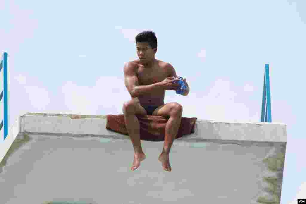 Pisey Windle​, a Cambodian-born U.S. diving champion, sits atop a diving board. Jordan hopes to inspire his homeland during his first-ever visit in Phnom Penh, Cambodia, May 12, 2016. (Hean Socheata/VOA Khmer)