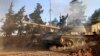 FILE - А volunteer fighter with Syrian government forces sits atop a tank in the province of Raqqa, Syria, Feb. 17, 2016. Backed by Russia and Iran, Syrian forces seen as much better positioned than the U.S.-led coalition and its regional allies to take 