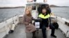 Presiding officer Caroline Sharkey and Garda Ronan Steede look after a ballot box that is taken by boat to the Island of Gola as voters go to polls for the 2024 election in Ireland on Nov. 29, 2024.